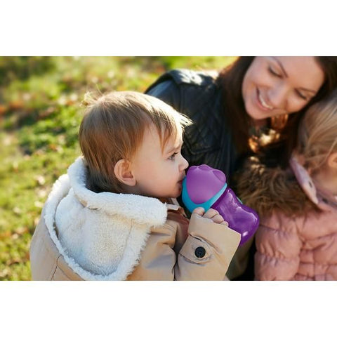 mother hold her childrens and one of them holding baby bottle